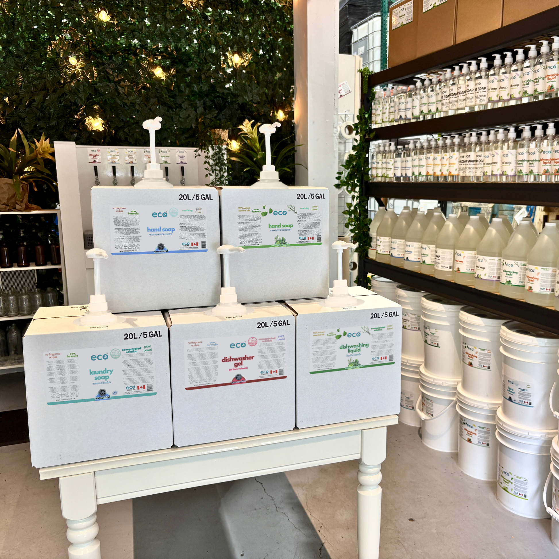 Refill station of refill boxes containing eco hand soap, laundry soap, dishwasher gel, and dish soap.