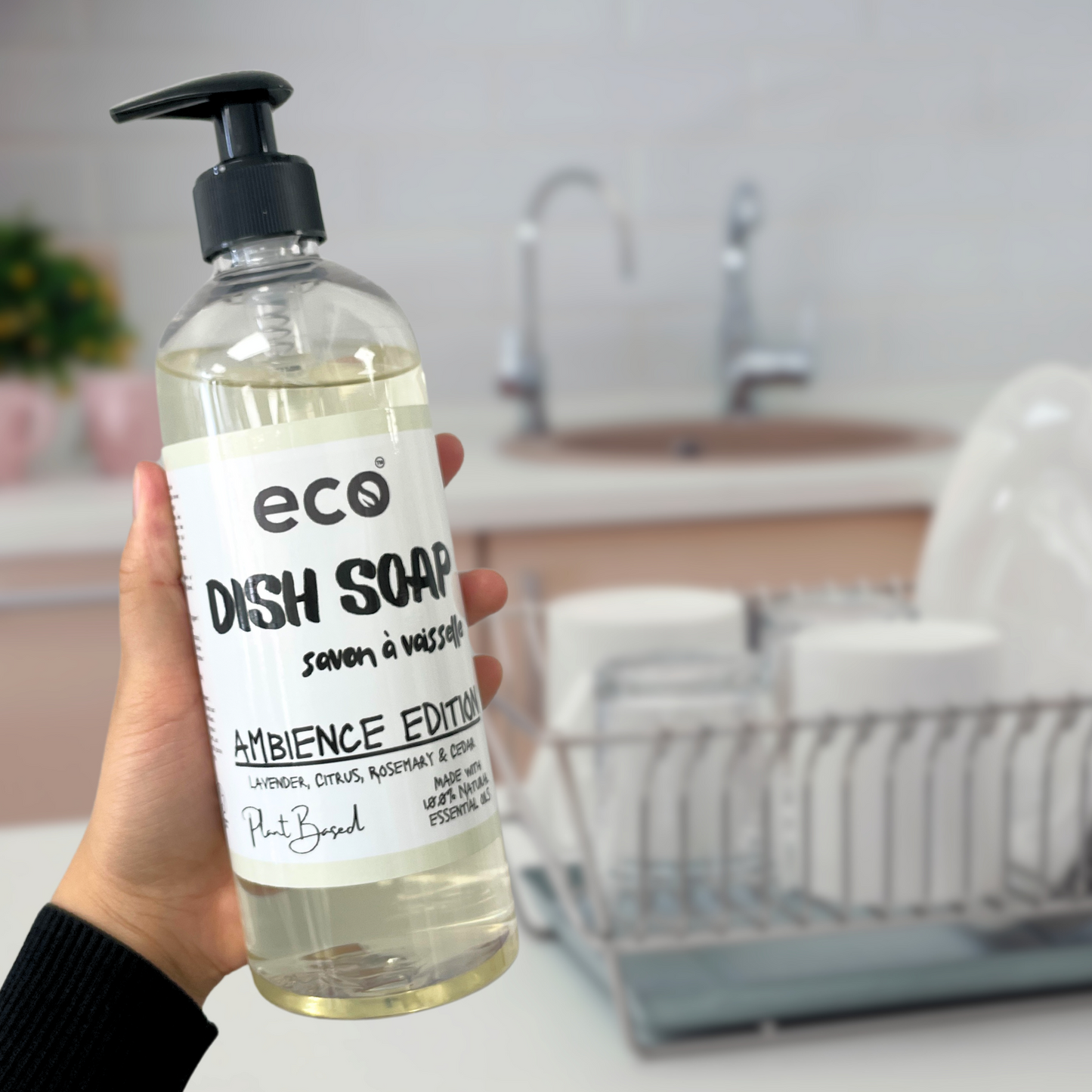 Person is holding a bottle of ambience edition eco dish soap, for a sustainable and eco-friendly home.