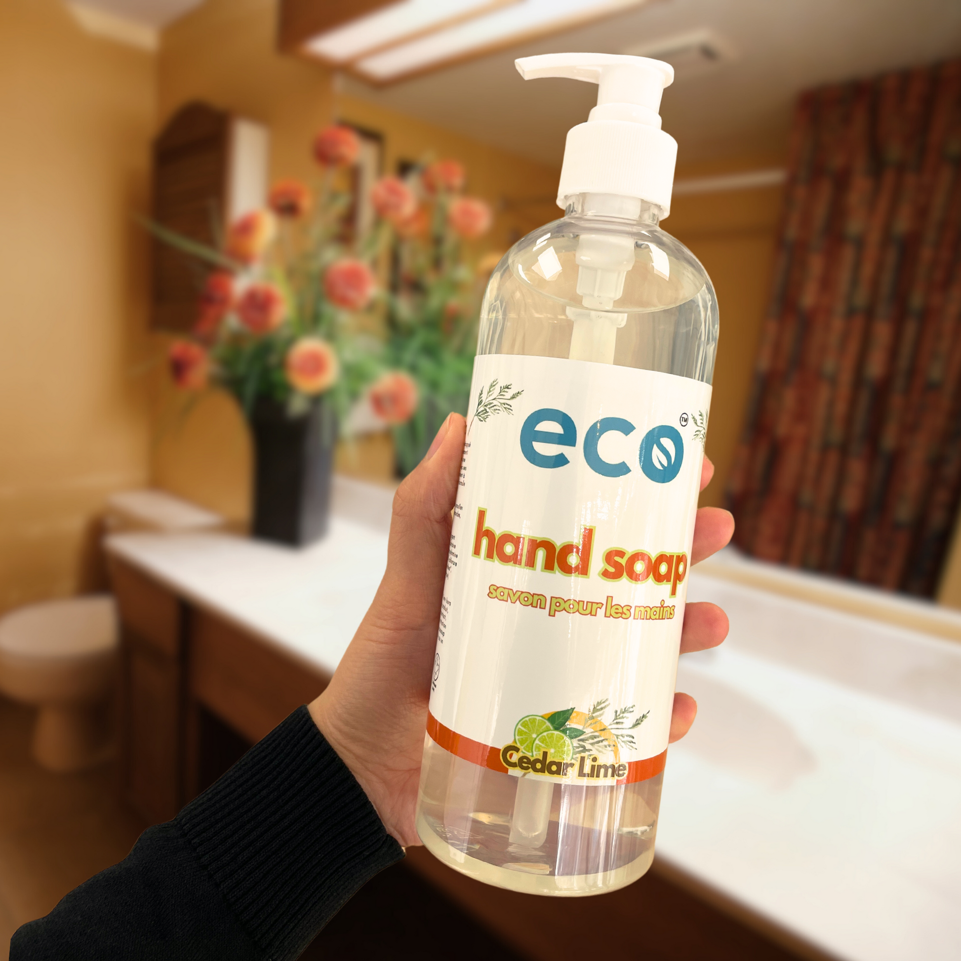 A bottle of eco hand soap held in a washroom, for an eco-friendly and sustainable washroom.